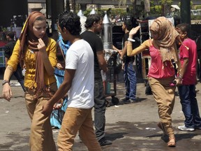 FILE - In this Aug. 19, 2012 file photo, Egyptian women are harassed by men on the first day of Eid al-Fitr holiday, in Cairo, Egypt. The state National Council for Women, the highest women's rights body in Egypt, has filed a complaint to the top prosecutor seeking legal action against lawyer Nabih el-Wahsh who called for the raping of women who wear ripped jeans on a TV talk show that aired Oct. 19, 2017. (AP Photo/Samuel Mohsen, El Shorouk Newspaper, File)