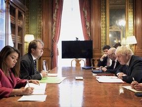 FILE - In this Wednesday Nov. 15, 2017 file photo, Britain's Foreign Secretary Boris Johnson, right, sits opposite Richard Ratcliffe, the husband of British-Iranian Nazanin Zaghari-Ratcliffe who was arrested and detained in Iran last year, during a meeting at the Foreign & Commonwealth Office in London. An Iranian official has acknowledged Tehran and Britain are talking about the possible release of some 400 million pounds held by London since the 1979 Islamic Revolution. The Telegraph newspaper of London reported Thursday, Nov. 16, 2017, that the money might be part of a bargain to free detained Iranian-British national Nazanin Zaghari-Ratcliffe. However, Foreign Ministry spokesman says the matters "are two separate issues and there is no link between them." (Stefan Rousseau/Pool Photo via AP, File)