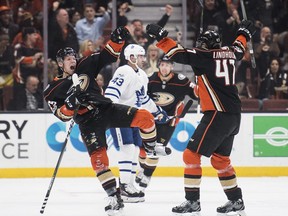 Anaheim Ducks right wing Ondrej Kase, left, and defenseman Hampus Lindholm, right, celebrate Kase's goal as Toronto Maple Leafs center Nazem Kadri looks away during the first period of an NHL hockey game Wednesday, Nov. 1, 2017, in Anaheim, Calif. (AP Photo/Kyusung Gong)