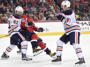 Washington Capitals forward Alex Ovechkin is caught in the middle between Edmonton Oilers defenceman Matt Benning, left, and forward Connor McDavid on Nov. 12.