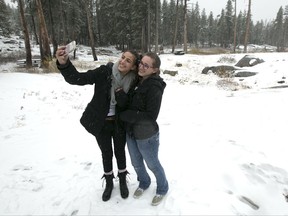 Emily, left, and her sister Stephanie pose for a selfie in the snow at a rest stop Friday, Nov. 3, 2017, at Donner Summit, Calif. A light snow fell in the upper elevations of the Sierra Nevada overnight, with up to 2 feet of snow forecast to fall in elevations above 8,000 feet and at least a foot of snow is expected in Donner and Tioga passes and other areas above 6,000 feet and up this weekend, forecasters said. (AP Photo/Rich Pedroncelli)