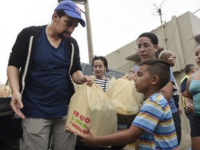 Actor and composer of Puerto Rican descent Lin Manuel Miranda distributes food to victims of Hurricane Maria in La Placita de Güisin, in Vega Alta, Puerto Rico, Tuesday, Nov. 7, 2017. (AP Photo/Carlos Giusti)