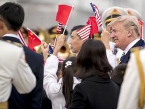 Children wave U.S. and Chinese flags as President Donald Trump arrives at Beijing Airport, Wednesday, Nov. 8, 2017, in Beijing, China. Trump is on a five-country trip through Asia traveling to Japan, South Korea, China, Vietnam and the Philippines. (AP Photo/Andrew Harnik)