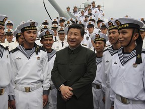 In this Dec. 8, 2012, photo released by Xinhua News Agency, Xi Jinping, center, general secretary of the Communist Party of China talks to sailors onboard the Haikou navy destroyer during his inspection of the Guangzhou military theater of operations of the People's Liberation Army (PLA) in Guangzhou, China.