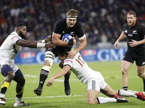 New Zealand's Luke Whitelock, center, is tackled by France's Francois Trinh-Duc, right, and Jonathan Danty, left, during a rugby union international match in Decines, near Lyon, central France, Tuesday, Nov. 14, 2017. (AP Photo/Laurent Cipriani)