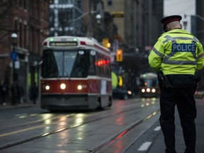 A police constable directs traffic at Jarvis and King St. during the second day of the King Street Transit Pilot on Monday, November 13, 2017. THE CANADIAN PRESS/Christopher Katsarov
