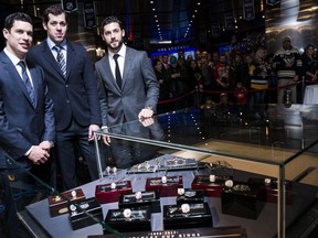 Pittsburgh Penguins' Sidney Crosby, left to right, Evgeni Malkin and Kris Letang pose for a portrait next to a display case holding the 2017 NHL championship ring that was donated to the Hockey Hall of Fame by the Pittsburgh Penguins, in Toronto on Wednesday, November 29, 2017. THE CANADIAN PRESS/Christopher Katsarov
