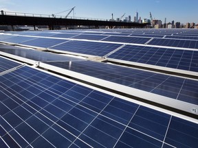 FILE - In this Feb. 14, 2017 file photo, a rooftop is covered with solar panels at the Brooklyn Navy Yard, in New York. Denver may become the latest city to require rooftop gardens or solar panels on big new buildings, which backers say will keep the outdoor air cooler, make storm water easier to manage and reduce the amount of energy burned by air conditioners. A ballot initiative mandating environment-friendly roofs in Denver had 53 percent approval in unofficial returns Thursday, with about 85 percent of the votes counted. (AP Photo/Mark Lennihan, File)