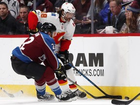 Calgary Flames right wing Jaromir Jagr, back, of the Czech Republic, fights for control of the puck with Colorado Avalanche center Colin Wilson in the first period of an NHL hockey game Saturday, Nov. 25, 2017, in Denver. (AP Photo/David Zalubowski)
