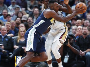 Denver Nuggets forward Paul Millsap, front, drives the lane past New Orleans Pelicans guard Jrue Holiday in the first half of an NBA basketball game Friday, Nov. 17, 2017, in Denver. (AP Photo/David Zalubowski)