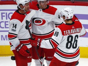 Carolina Hurricanes center Victor Rask, center, of Sweden, is congratulated after scoring a goal by right wing Justin Williams, left, and left wing Teuvo Teravainen, of Finland, against the Colorado Avalanche in the first period of an NHL hockey game Thursday, Nov. 2, 2017, in Denver. (AP Photo/David Zalubowski)