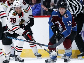 Chicago Blackhawks left wing Ryan Hartman, left, fights for control of the puck with Colorado Avalanche center Alexander Kerfoot in the first period of an NHL hockey game Saturday, Oct. 28, 2017, in Denver. (AP Photo/David Zalubowski)