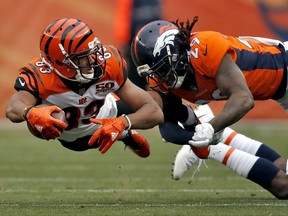 Cincinnati Bengals wide receiver Tyler Boyd (83) lunges for yards as Denver Broncos free safety Bradley Roby (29) makes the hit during the first half of an NFL football game, Sunday, Nov. 19, 2017, in Denver. (AP Photo/David Zalubowski)