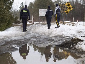 Two Liberal MPs are headed back to the U.S. in an effort to fend off a new surge of asylum seekers at the Canada-U.S. border after the latest shift in U.S. immigration policy. Three RCMP officers look over to the United States on the border with Canada where many asylum seekers have been crossing the United States, Tuesday, March 28, 2017 near Hemmingford, Que. THE CANADIAN PRESS/Paul Chiasson