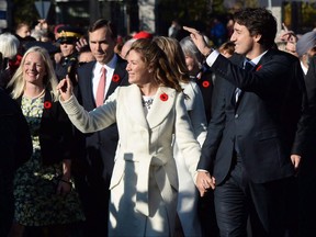 Prime Minister-designate Justin Trudeau and his wife Sophie Gregoire-Trudeau lead the new Liberal cabinet to Rideau Hall in Ottawa on Wednesday, Nov. 4, 2015. The federal government has launched a website to track the 364 commitments Prime Minister Justin Trudeau outlined in mandate letters to his cabinet ministers. THE CANADIAN PRESS/Sean Kilpatrick