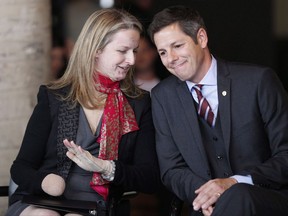 Members of a police bomb squad have testified about the aftermath of an explosion at a Winnipeg law office that cost one lawyer her right hand. Lawyer Maria Mitousis, who was injured in an office bombing on July 3, leans in to Winnipeg Mayor Brian Bowman prior to speaking to media during a press conference in Winnipeg, Wednesday, September 30, 2015. THE CANADIAN PRESS/John Woods