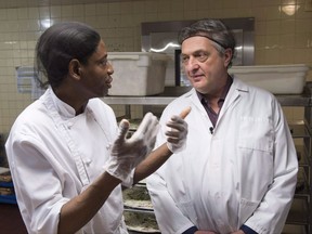 The head of the United Nations refugee agency says the Liberal government must keep Canada's refugee determination system free of politics. Filippo Grandi, the UN high commissioner for refugees, right, meets with Jean-Claude Puati, 40, a refugee from the Democratic Republic of Congo, while at work in a hospital cafeteria Friday, November 3, 2017 in Montreal. THE CANADIAN PRESS/Paul Chiasson
