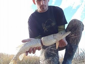 Adam Turnbull holds a Northern Pike, shown in this handout image, he caught near Medicine Hat, Alberta on Saturday Oct. 28, 2017. THE CANADIAN PRESS/Adam Turnbull