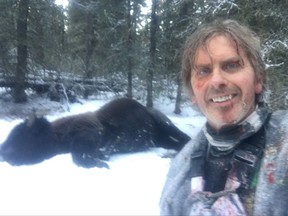 Natural resource officer Todd Pilgrim is shown in this handout image with a dead bison on the ground behind him. The Yukon hunter has a harrowing tale of survival after tangling with a bison, the largest land mammal in North America.