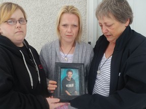 Leianne Barthel, centre, holds photo of her son Kegan McCallum on Tuesday Nov. 14, 2017. Kegan McCallum died in hospital after being found with a gunshot wound at a home in Meadow Lake on Monday. THE CANADIAN PRESS/HO-CKOM-Chris Vandenbreekel
