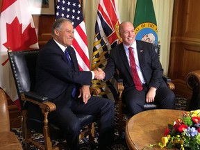 B.C. Premier John Horgan, right, shakes hands with Washington State Gov. Jay Inslee as the two meet at legislature in Victoria on Tuesday Nov. 21, 2017. THE CANADIAN PRESS/Dirk Meissner