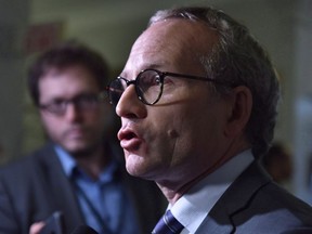 Quebec Public Security Minister and Municipal Affairs Minister Martin Coiteux responds to reporters questions at the entrance of a government caucus meeting Tuesday, September 19, 2017 at the legislature in Quebec City. Quebec's legislature has passed a motion against Transport Canada's directive allowing airline passengers to carry small blades, including kirpans.THE CANADIAN PRESS/Jacques Boissinot