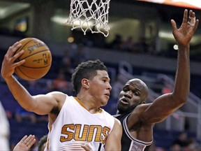 Phoenix Suns' Devin Booker, left, looks to pass the ball against San Antonio Spurs' Joel Anthony during the second half of an NBA preseason basketball game in Phoenix on Oct. 3, 2016. Veteran centre Anthony remembers what it was like the last time Canada earned a spot at the FIBA World Cup. THE CANADIAN PRESS/AP, Ross D. Franklin