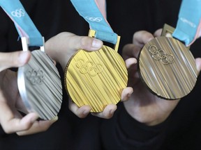 South Korean athletes pose with the silver, gold and bronze medals, from left, for the Pyeongchang 2018 Winter Olympics during an unveiling ceremony in Seoul, South Korea, Thursday, Sept. 21, 2017. If the latest virtual Olympic medal table is to believed, Canada will finish third in the overall standings at the Winter Games with 31 medals -- just five of them gold. THE CANADAIN PRESS/AP, Lee Jin-man)