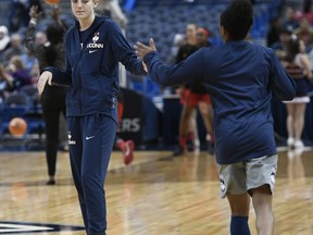 Connecticut's Katie Lou Samuelson, left wears a boot on her left foot as she slaps hands with teammate Crystal Dangerfield, right, before the first half an NCAA women's college basketball game against Maryland, Sunday, Nov. 19, 2017, in Hartford, Conn. (AP Photo/Jessica Hill)