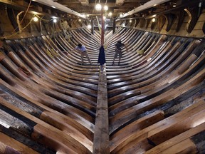In this Nov. 3, 2017 photo, shipwrights Jamie Kirschner, left, and Tucker Yaro clean out the hold of the Mayflower II at Mystic Seaport's H.B. duPont Preservation Shipyard in Mystic, Conn. Restoration of the ship, a replica of the vessel that brought Pilgrims to Massachusetts in 1620, is expected to be completed in 2019 when it will return to its home port in Plymouth, Mass. (Sean D. Elliot/The Day via AP)