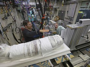 In this Nov. 27, 2017 photo, Argonne X-ray scientist Jonathan Almer, left, and Northwestern University Feinberg School of Medicine professor Stuart Stock, right, prepare to use high-energy X-ray beams to learn more about the 1,800-year-old mummified remains believed to be a 5-year-old girl in Lemont, Ill. Researchers from Northwestern and Argonne National Laboratory are using advanced technology to unwrap the mysteries of the mummy. They say high-energy beams from a synchrotron will provide molecular information about what is inside. (AP Photo/Teresa Crawford)