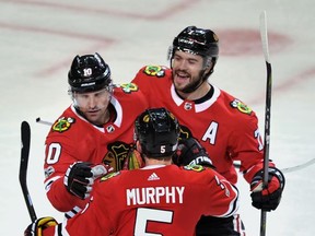 Chicago Blackhawks' Patrick Sharp (10) celebrates with teammates Brent Seabrook (7) and Connor Murphy (5) after scoring a goal during the first period of an NHL hockey game against the Anaheim Ducks, Monday, Nov. 27, 2017, in Chicago. (AP Photo/Paul Beaty)