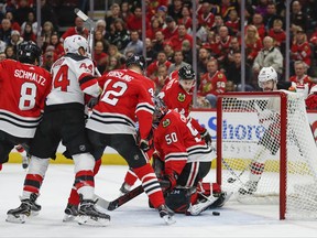 New Jersey Devils left wing Miles Wood (44) scores against Chicago Blackhawks goalie Corey Crawford (50) during the first period of an NHL hockey game Sunday, Nov. 12, 2017, in Chicago. (AP Photo/Kamil Krzaczynski)