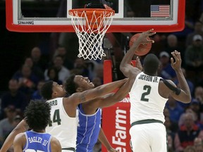 Michigan State forward Jaren Jackson Jr. (2) blocks the shot of Duke forward Wendell Carter Jr, center, as Nick Ward also defends during the first half of an NCAA college basketball game Tuesday, Nov. 14, 2017, in Chicago. (AP Photo/Charles Rex Arbogast)
