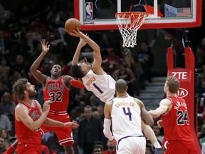 Phoenix Suns' Devin Booker (1) drives to the basket past Chicago Bulls' Kris Dunn (32) as Lauri Markkanen (24) Tyson Chandler (4) and Robin Lopez watch during the first half of an NBA basketball game Tuesday, Nov. 28, 2017, in Chicago. (AP Photo/Charles Rex Arbogast)