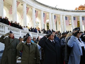 CORRECTS MISSPELLED - Veterans salute as the colors are presented before Vice President Mike Pence speaks during a Veterans Day ceremony at Arlington National Cemetery, Saturday, Nov. 11, 2017 in Washington. (AP Photo/Alex Brandon)