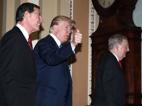 President Donald Trump walks with Senate Majority Leader Mitch McConnell of Ky., right, and Sen. John Barrasso, R-Wy., left, as he arrives to meet with Senate Republicans on Capitol Hill, Tuesday, Nov. 28, 2017. (AP Photo/Alex Brandon)