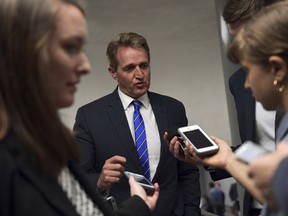 Sen. Jeff Flake, R-Ariz., is surrounded by reporters on his way to go vote on Capitol Hill in Washington, Tuesday, Nov. 7, 2017. (AP Photo/Susan Walsh)