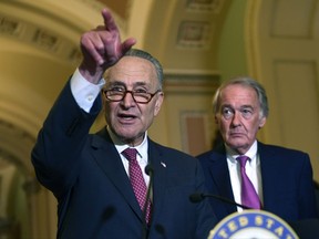 Senate Minority Leader Sen. Chuck Schumer of N.Y., left, standing with Sen. Edward Markey, D-Mass., right, speaks to reporters following the weekly Democratic policy luncheon on Capitol Hill in Washington, Tuesday, Oct. 31, 2017. (AP Photo/Susan Walsh)