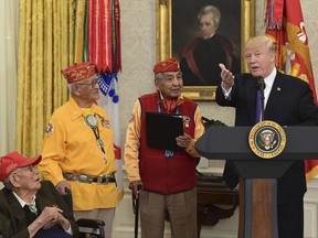 President Donald Trump, right, speaks during a meeting with Navajo Code Talkers including Fleming Begaye Sr., seated left, Thomas Begay, second from left, and Peter MacDonald, second from right, in the Oval Office of the White House in Washington, Monday, Nov. 27, 2017. (AP Photo/Susan Walsh)