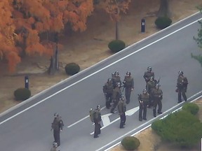 This screengrab made from video footage released by the United Nations Command on November 22, 2017 shows North Korea soldiers gathering on the north side of the Joint Security Area of the Demilitarized Zone  after the defection of a North Korean soldier.