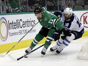 Dallas Stars center Devin Shore (17) attempts to gain control of the puck in front of Winnipeg Jets center Bryan Little (18) in the first period of an NHL hockey game, Monday, Nov. 6, 2017, in Dallas. (AP Photo/Tony Gutierrez)