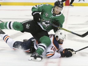 Dallas Stars left wing Antoine Roussel (21) and Edmonton Oilers center Ryan Strome (18) fall to the ice during the first period of an NHL hockey game in Dallas, Saturday, Nov. 18, 2017. (AP Photo/LM Otero)