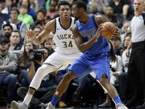 Milwaukee Bucks forward Giannis Antetokounmpo (34), of Greece, defends as Dallas Mavericks' Harrison Barnes (40) looks for an opportunity to the basket in the first half of an NBA basketball game, Saturday, Nov. 18, 2017, in Dallas. (AP Photo/Tony Gutierrez)