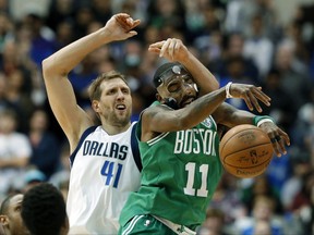 Boston Celtics guard Kyrie Irving (11) intercepts a pass intended for Dallas Mavericks' Dirk Nowitzki (41) of Germany in the second half of an NBA basketball game, Monday, Nov. 20, 2017, in Dallas. The Celtics won in overtime, 110-102. (AP Photo/Tony Gutierrez)