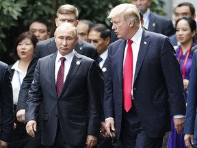 U.S. President Donald Trump, right, and Russia's President Vladimir Putin talk during the family photo session at the APEC Summit in Danang, Vietnam Saturday, Nov. 11, 2017. Trump and Putin may not be having a formal meeting while they're in Vietnam for an economic summit. But the two appear to be chumming it up nonetheless. Snippets of video from the Asia-Pacific Economic Cooperation conference Saturday have shown the leaders chatting and shaking hands at events including a world leaders' group photo. (Jorge Silva/Pool Photo via AP)