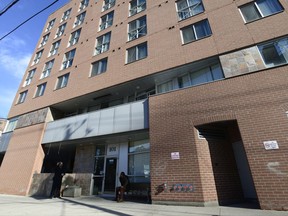 People stand outside the front door of Sojourn House shelter in Toronto on Tuesday Nov. 21, 2017. The City of Toronto is considering a re-brand of homeless shelter services, in an effort to combat NIMBYism and better reflect its evolving work. THE CANADIAN PRESS/Doug Ives