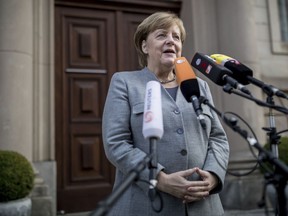 German Chancellor and chairwomen of the German Christian Democratic Union party  (CDU), Angela Merkel, addresses the media as she arrives for exploratory talks on a coalition between the CDU, the Christian Social Union party  (CSU), the German Free Democratic Party (FDP) and the Green Party in Berlin, Germany, Friday, Nov. 3, 2017. (Michael Kappeler/dpa via AP)