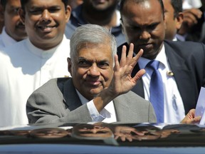 Sri Lankan Prime Minister Ranil Wickremesinghe waves to media as he leaves after appearing before a presidential commission of inquiry into issuance of treasury bonds in Colombo, Sri Lanka, Monday, Nov. 20, 2017. (AP Photo/Eranga Jayawardena)