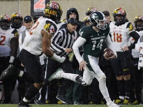 Michigan State quarterback Brian Lewerke, right, runs for a first down against Maryland's Chandler Burkett during the first half of an NCAA college football game, Saturday, Nov. 18, 2017, in East Lansing, Mich. (AP Photo/Al Goldis)
